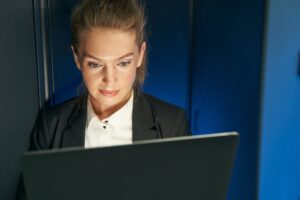 Female technician using laptop to analyze server