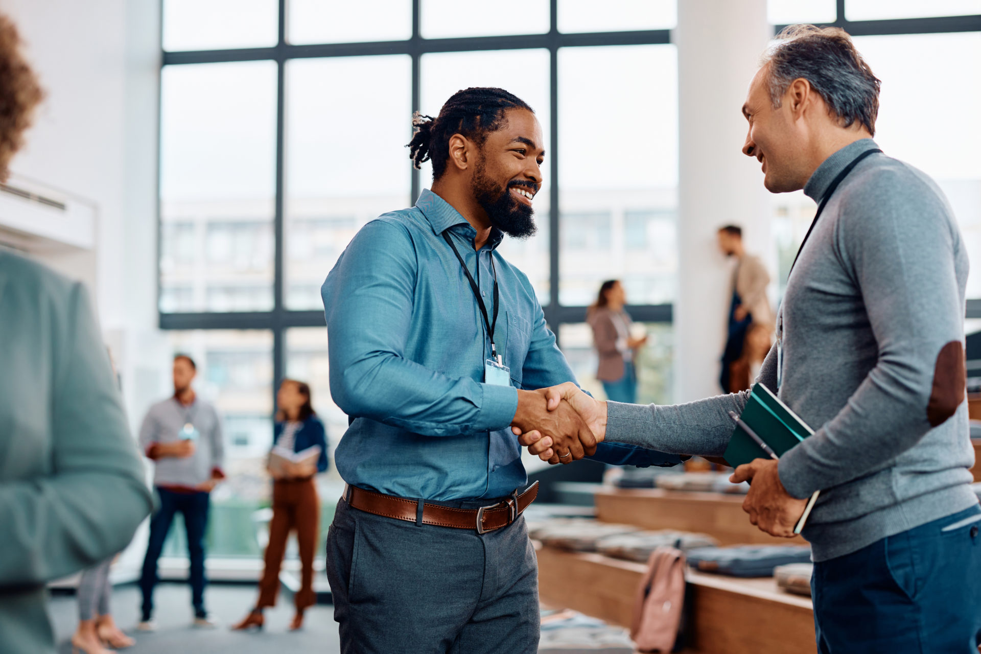 happy-businessmen-greeting-while-attending-an-education-event-at-conference-hall--e1694673006317.jpg