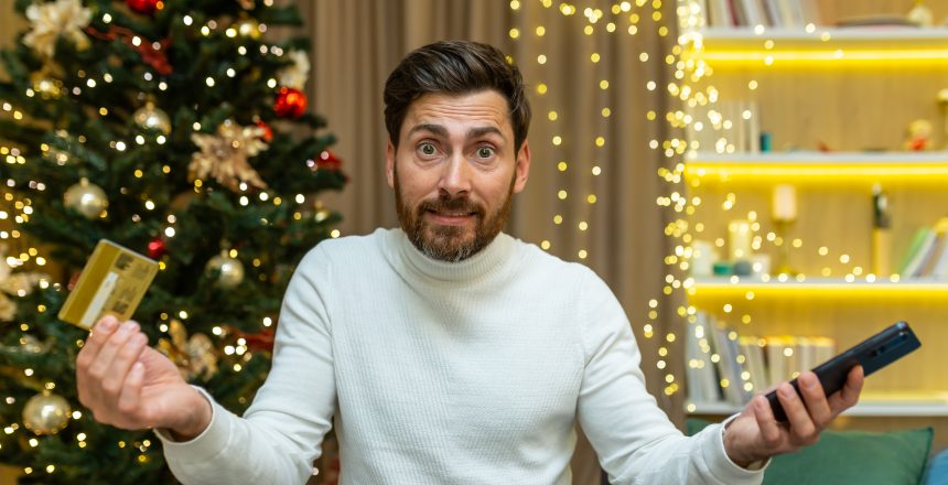 dissatisfied and disappointed man looking at camera nervously trying to do online shopping while