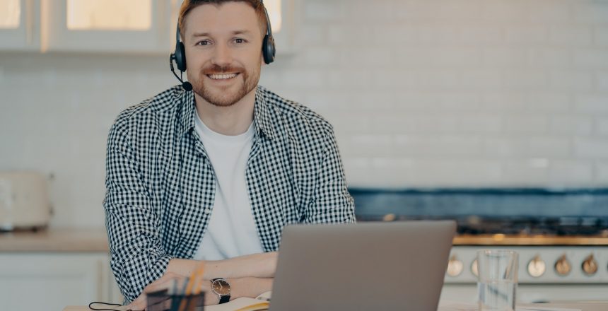 handsome glad man customer support manager gives advice or consultation to clients works online